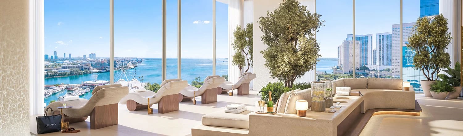 Sunlit residents’ lounge with chaise seating and floor-to-ceiling bay views